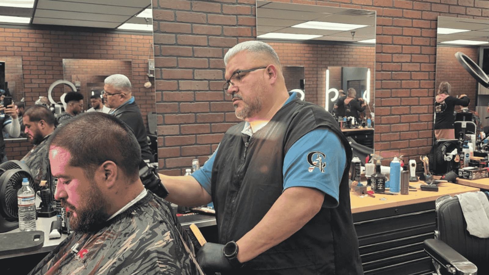 Barbero de Cannos Hair Cuts en Elgin, IL, realizando un corte de pelo profesional a un cliente.